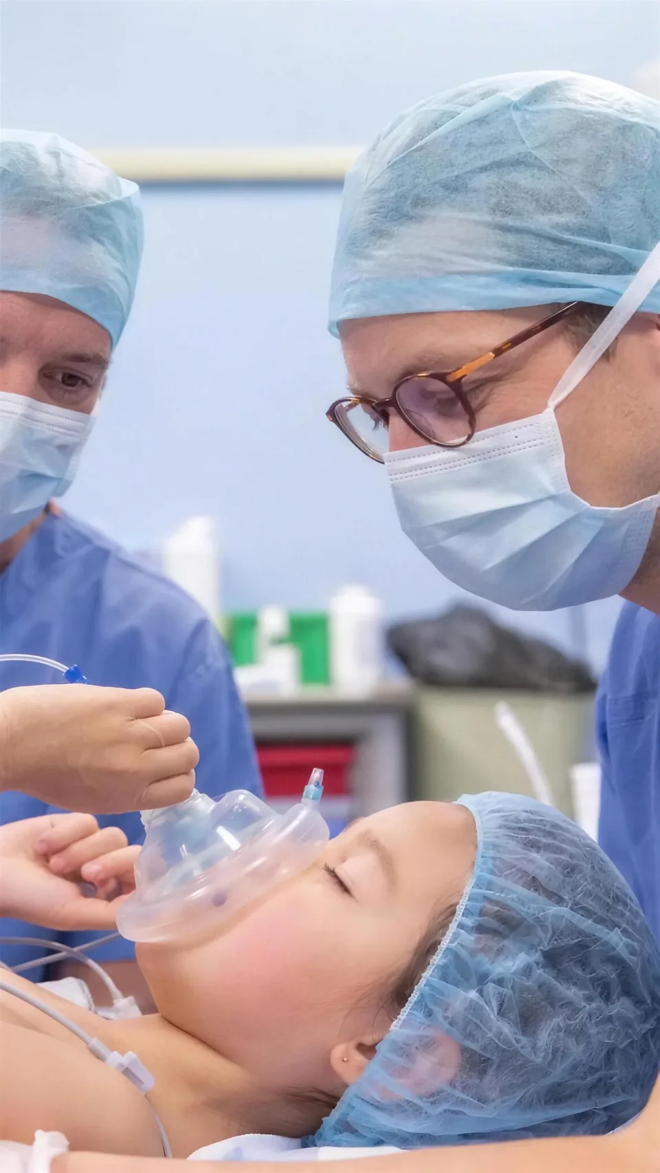 Induction au masque chez un enfant, accompagnée par deux soignants au bloc